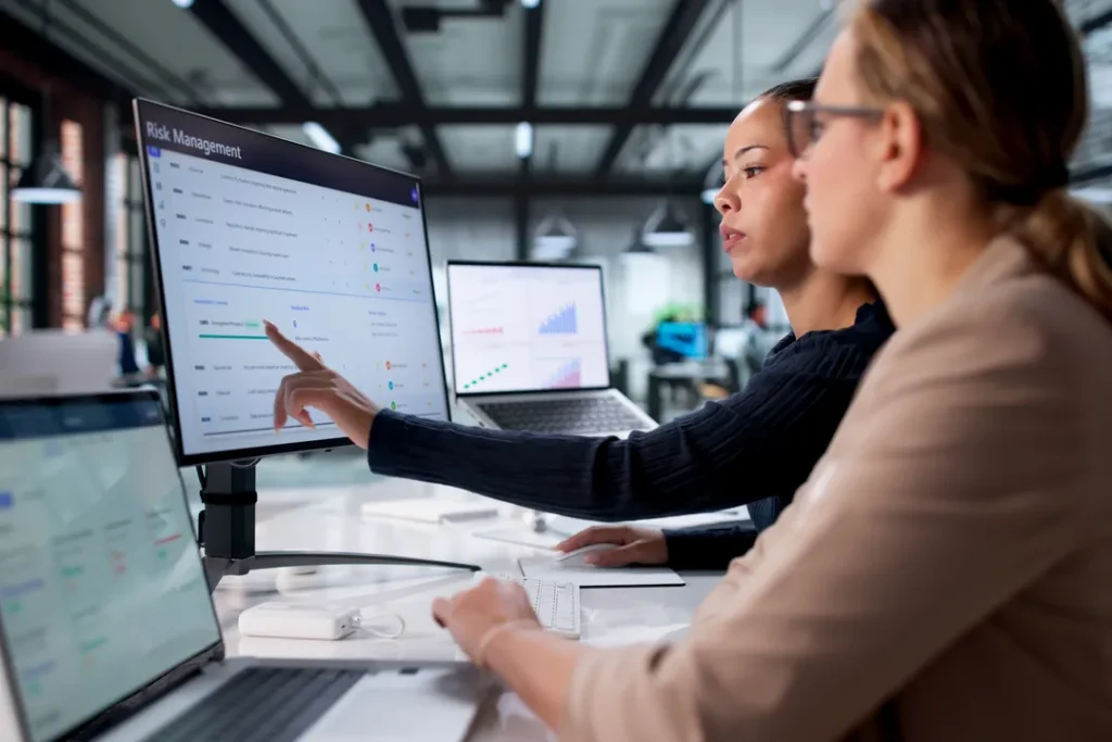 Cyber security specialists reviewing a risk management dashboard and analysing security data to protect business systems